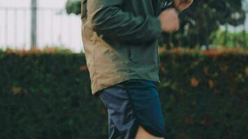 Attractive young man stretching in the park before running at the sunset focus on shoes video