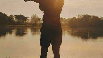 Attractive young man stretching in the park before running at the sunset focus on shoes video