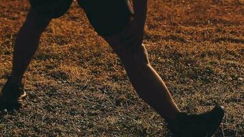 Attractive young man stretching in the park before running at the sunset focus on shoes video