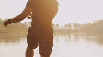 Attractive young man stretching in the park before running at the sunset focus on shoes video