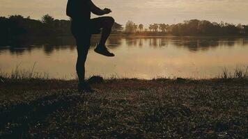 attrayant Jeune homme élongation dans le parc avant fonctionnement à le le coucher du soleil concentrer sur des chaussures video