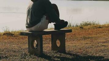 atractivo joven hombre extensión en el parque antes de corriendo a el puesta de sol atención en Zapatos video