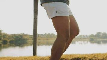 Attractive young man stretching in the park before running at the sunset focus on shoes video