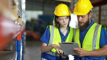 operazione lavoratori controllo e ispezionando carico per pila elementi per spedizione. maschi lavoratore controllo il memorizzare fabbrica. industria fabbrica magazzino. lavoratore lettura pacchetto nel magazzino. video