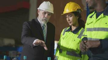 Senior patrão Gerente inspecionando com funcionários engenheiros mulher e africano homem.equipe verificação construção estrutura do fábrica prédio. armazém com aço cobertura estrutura e máquina instalação. video