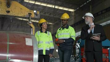 Senior patrão Gerente inspecionando com funcionários engenheiros mulher e africano homem.equipe verificação construção estrutura do fábrica prédio. armazém com aço cobertura estrutura e máquina instalação. video