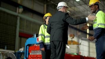 anziano capo manager ispezionando con personale ingegneri donna e africano man.team controllo costruzione struttura di fabbrica costruzione. magazzino con acciaio tetto struttura e macchina installazione. video