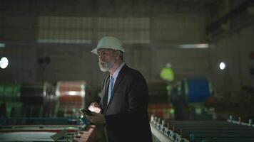 Portrait engineer Senior boss standing confident in steel warehouse. Concept of smart industry operation and maintenance. older engineer with beard mustache on face standing. video
