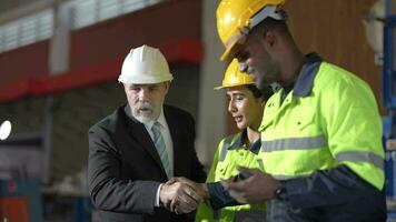 mayor jefe gerente inspeccionando con personal ingenieros mujer y africano hombre.equipo comprobación construcción estructura de fábrica edificio. almacén con acero techo estructura y máquina instalación. video