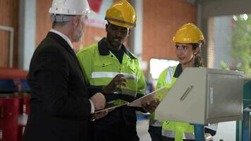 mayor jefe gerente inspeccionando con personal ingenieros mujer y africano hombre.equipo comprobación construcción estructura de fábrica edificio. almacén con acero techo estructura y máquina instalación. video