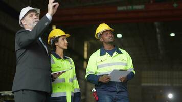 senior baas manager inspecteren met personeel ingenieurs vrouw en Afrikaanse man.team controle bouw structuur van fabriek gebouw. magazijn met staal dak structuur en machine installatie. video