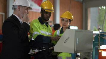 Senior patrão Gerente inspecionando com funcionários engenheiros mulher e africano homem.equipe verificação construção estrutura do fábrica prédio. armazém com aço cobertura estrutura e máquina instalação. video