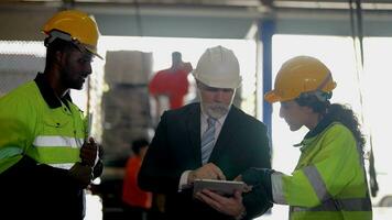 Senior patrão Gerente inspecionando com funcionários engenheiros mulher e africano homem.equipe verificação construção estrutura do fábrica prédio. armazém com aço cobertura estrutura e máquina instalação. video