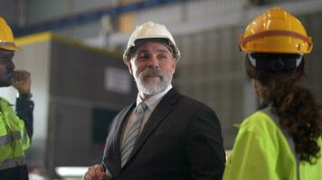 Sénior patron directeur inspecter avec Personnel ingénieurs femme et africain homme.équipe vérification construction structure de usine bâtiment. entrepôt avec acier toit structure et machine installation. video