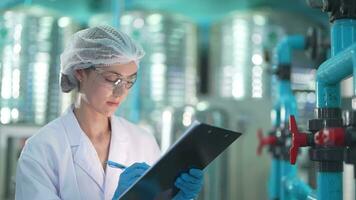 scientist worker checking the quality of Reverse osmosis machine system at the industrial factory. Female worker recording data at the control panel with measure pressure for recycle portable plant. video