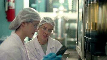 scientifique femme ouvrier vérification et surveillance le contrôle panneau sur machine système à le industriel usine. femelle ouvrier enregistrement Les données à le contrôle panneau avec mesure pression de l'eau niveau. video