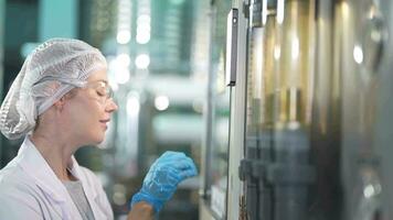 wetenschapper vrouw arbeider controle en toezicht houden de controle paneel Aan machine systeem Bij de industrieel fabriek. vrouw arbeider opname gegevens Bij de controle paneel met meten druk van water niveau. video