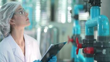 scientist worker checking the quality of Reverse osmosis machine system at the industrial factory. Female worker recording data at the control panel with measure pressure for recycle portable plant. video