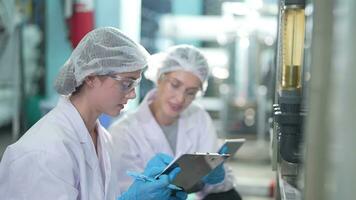 Wissenschaftler Frau Arbeiter Überprüfung und Überwachung das Steuerung Panel auf Maschine System beim das industriell Fabrik. weiblich Arbeiter Aufzeichnung Daten beim das Steuerung Panel mit messen Druck von Wasser eben. video