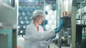 Wissenschaftler Frau Arbeiter Überprüfung und Überwachung das Steuerung Panel auf Maschine System beim das industriell Fabrik. weiblich Arbeiter Aufzeichnung Daten beim das Steuerung Panel mit messen Druck von Wasser eben. video