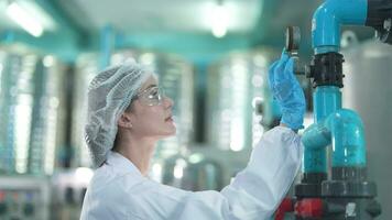 scientist worker checking the quality of Reverse osmosis machine system at the industrial factory. Female worker recording data at the control panel with measure pressure for recycle portable plant. video