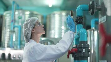 scientist worker checking the quality of Reverse osmosis machine system at the industrial factory. Female worker recording data at the control panel with measure pressure for recycle portable plant. video