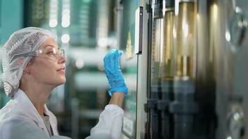 scienziato donna lavoratore controllo e monitoraggio il controllo pannello su macchina sistema a il industriale fabbrica. femmina lavoratore registrazione dati a il controllo pannello con misurare pressione di acqua livello. video