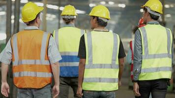 grupo de diversidad fábrica trabajador personas inspeccionando y comprobación local depósito, asiático, blanco caucásico y asiático personas en pesado máquina a industria fábrica. concepto ingeniero operando y control. video