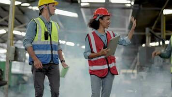 grupo do diversidade fábrica trabalhador pessoas inspecionando e verificação local armazém, asiático, branco caucasiano e ásia pessoas dentro pesado máquina às indústria fábrica. conceito engenheiro operativo e ao controle. video