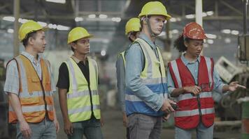 grupo de diversidad fábrica trabajador personas inspeccionando y comprobación local depósito, asiático, blanco caucásico y asiático personas en pesado máquina a industria fábrica. concepto ingeniero operando y control. video