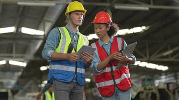 fábrica trabajador personas inspeccionando.mujeres y africano mujer personas hablando en frente de pesado máquinas a industria fábrica. ingeniero operando y control. equipo de hombre operando en sitio inspección. video