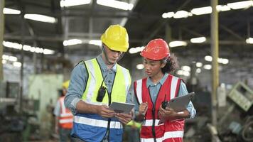 usine ouvrier gens inspecter.les femmes et africain femme gens parlant dans de face de lourd Machines à industrie usine. ingénieur en fonctionnement et contrôle. équipe de homme en fonctionnement sur site inspection. video