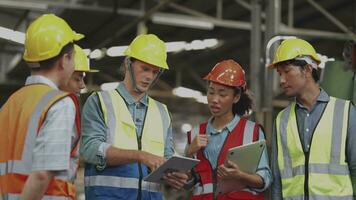 grupo de diversidad fábrica trabajador personas inspeccionando y comprobación local depósito, asiático, blanco caucásico y asiático personas en pesado máquina a industria fábrica. concepto ingeniero operando y control. video