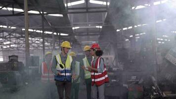 grupo de diversidad fábrica trabajador personas inspeccionando y comprobación local depósito, asiático, blanco caucásico y asiático personas en pesado máquina a industria fábrica. concepto ingeniero operando y control. video