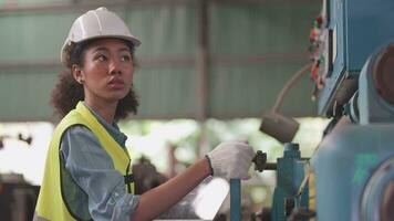 trabalhadores fábrica africano mulher trabalhando às pesado máquina. grupo do pessoas operativo dentro frente do motor fabricado às industrial plantar fábrica. inteligente indústria trabalhador operativo. mulher sorridente e feliz. video