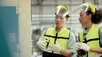 fábrica ingeniero trabajadores comprobación y ajustando máquina panel. en el antecedentes desenfocado grande industrial fábrica. retrato pesado industria trabajador hombre. calidad garantía para fabricación industria. video