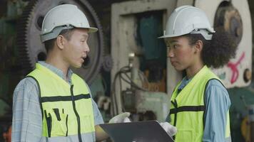 fabriek ingenieur arbeiders controle en aanpassen machine paneel. in de achtergrond ongericht groot industrieel fabriek. portret zwaar industrie arbeider Mens. kwaliteit zekerheid voor fabricage industrie. video