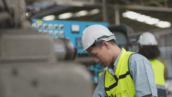 Arbeitskräfte Fabrik asiatisch Mann Arbeiten beim schwer Maschine. Gruppe von Menschen Betriebs im Vorderseite von Motor hergestellt beim industriell Pflanze Fabrik. Clever Industrie Arbeiter Betriebs. Frau lächelnd und glücklich. video