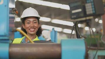 lavoratori fabbrica africano donna Lavorando a pesante macchina. gruppo di persone operativo nel davanti di motore manufatto a industriale pianta fabbrica. inteligente industria lavoratore operativo. donna sorridente e contento. video