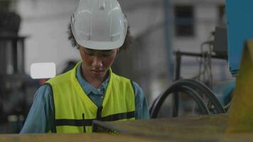 lavoratori fabbrica africano donna Lavorando a pesante macchina. gruppo di persone operativo nel davanti di motore manufatto a industriale pianta fabbrica. inteligente industria lavoratore operativo. donna sorridente e contento. video