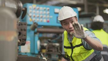 trabajadores fábrica asiático hombre trabajando a pesado máquina. grupo de personas operando en frente de motor fabricado a industrial planta fábrica. inteligente industria trabajador operando. mujer sonriente y contento. video