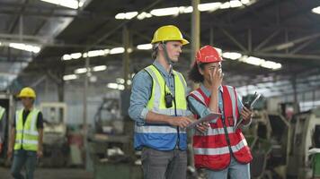 fábrica trabajador personas inspeccionando.mujeres y africano mujer personas hablando en frente de pesado máquinas a industria fábrica. ingeniero operando y control. equipo de hombre operando en sitio inspección. video