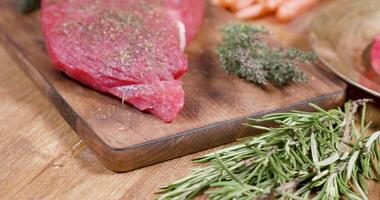 révélateur coup de une du boeuf steak bien chevronné dans une ancien composition. panoramique autour une pièce de brut Viande mis sur en bois planche. video