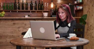 mujer de negocios paga con su teléfono vía nfc pagos a un camarero en un Clásico y estilizado café tienda video