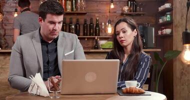 negocio socios trabajando desde un local café tienda. que se discute un nuevo proyecto en un pequeño acogedor restaurante mientras sentado a un mesa. video