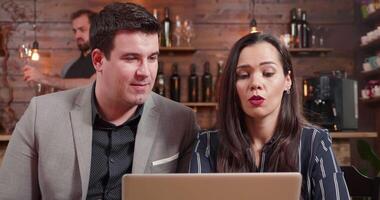 Close up shot of a male and female business partners discussing over whats on laptop screen. Looking at a notebook screen and having a pleasant conversation. video
