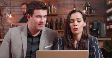 Close up shot of a male and female business partners discussing over whats on laptop screen. Looking at a notebook screen and having a pleasant conversation. video