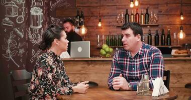 Bearded bartender bringing beer to lovely couple in the vintage rustic pub video