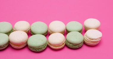 Delicious and fresh macaroons on pink background in studio video