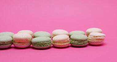 Sweet delicious macaroons dessert on pink background in studio video